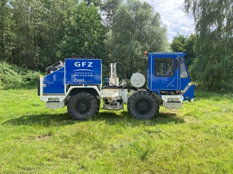 Blauer Seismik Truck, der auf einer Wiese steht. 